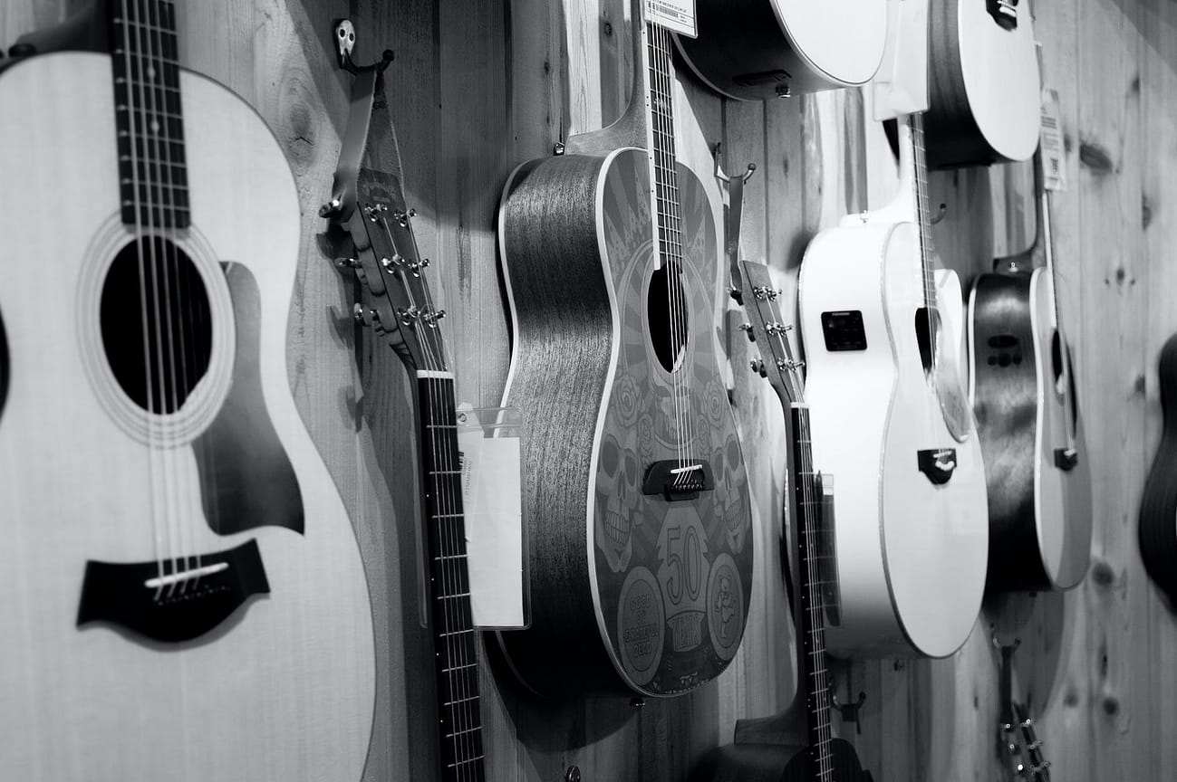 gray scale photo of acoustic guitars